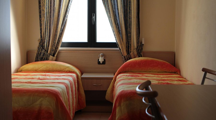 Camera con due letti singoli di Casa Rosmini illuminata dalla finestra